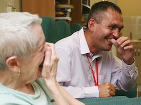 two people at a computer laughing