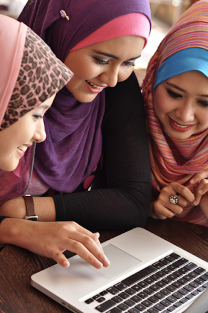 three young women round a tablet