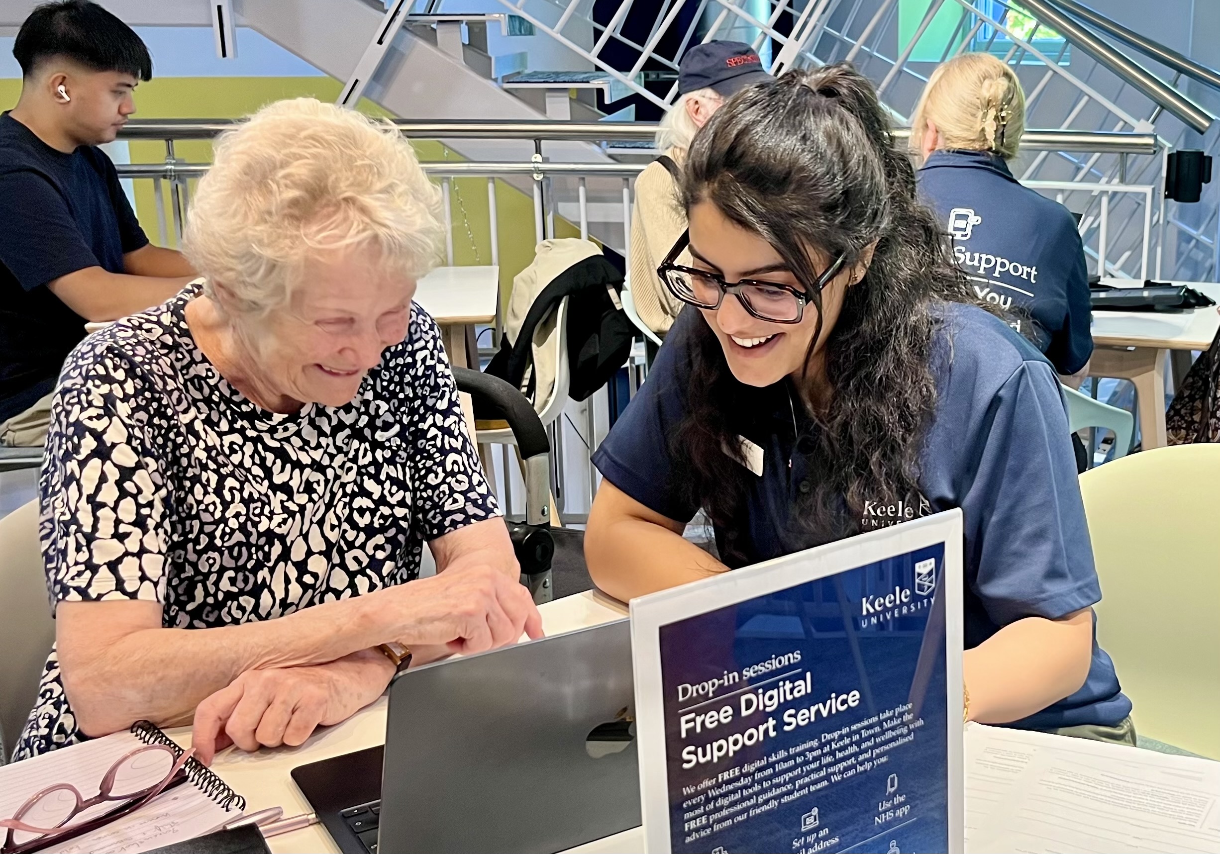a student and an older person they're helping at a digital drop in centre