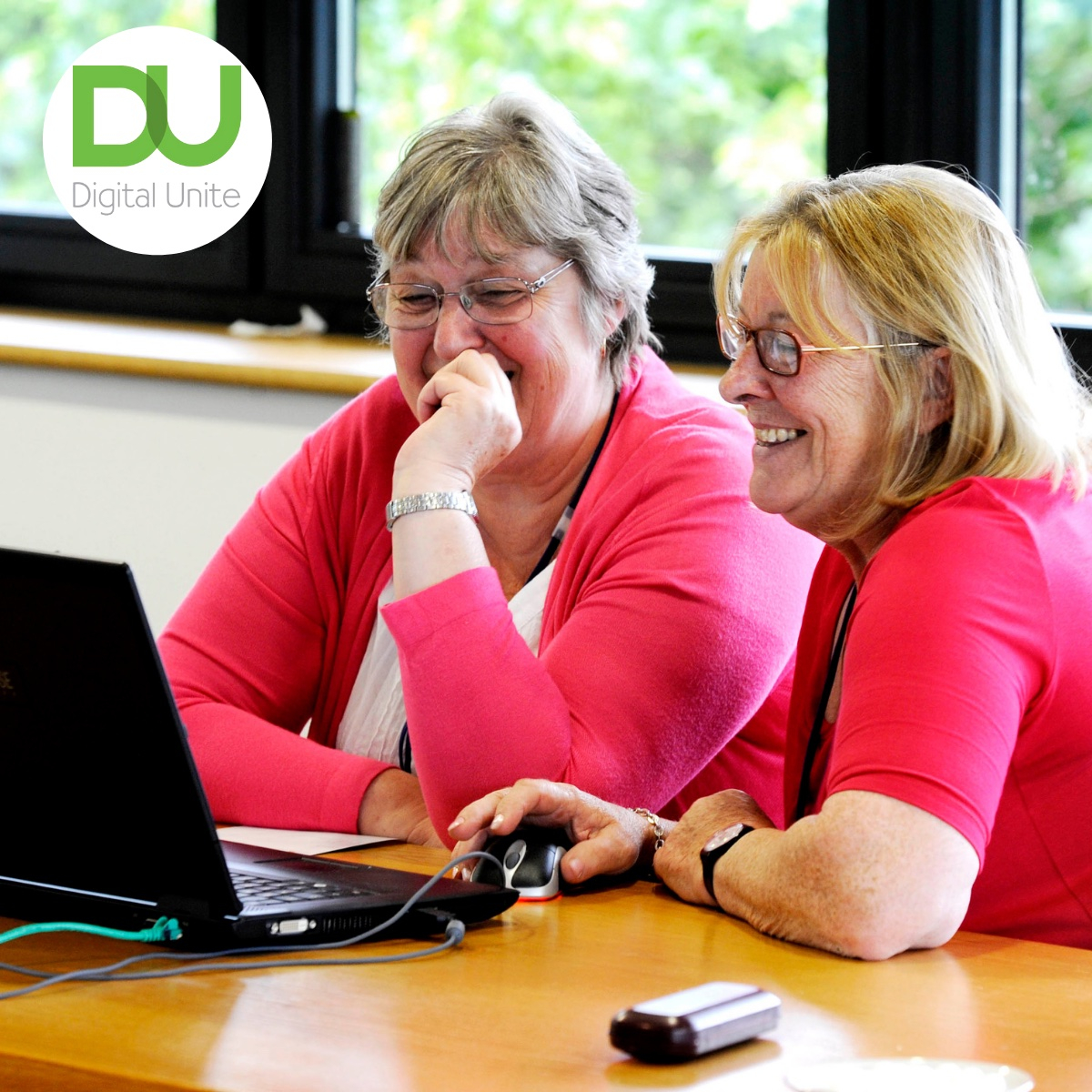 Two women at a computer smiling