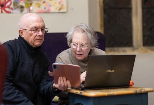 2 people looking at a computer tablet confused