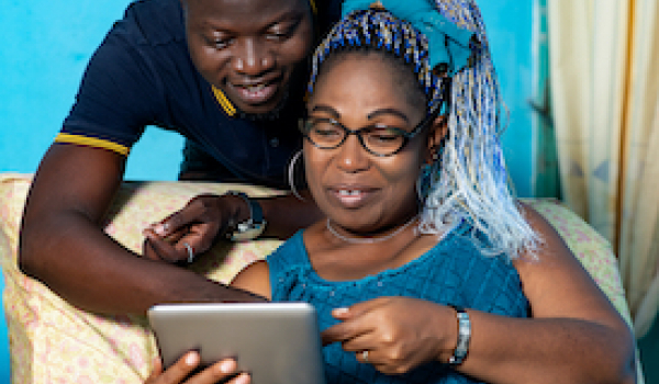 mum and younger person look at a tablet