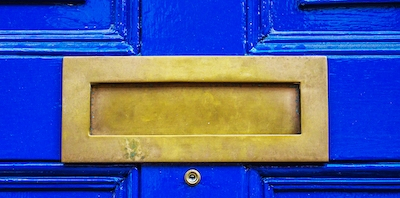 A letter box on a blue front door