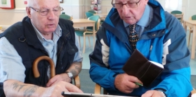 two old men looking at a tablet