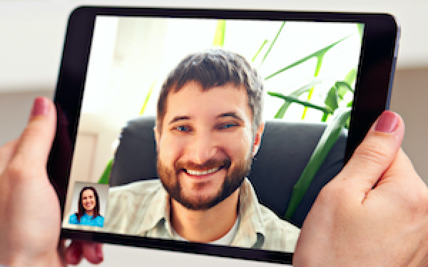 Tablet computer showing a man's face on a video call with a woman