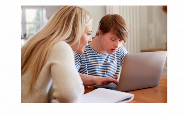 someone helping someone with a learning disability use a computer