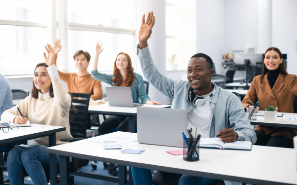 people at a workshop raise hands