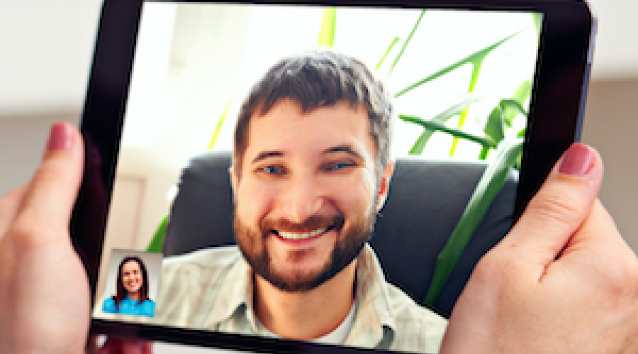 Tablet computer showing a man's face on a video call with a woman