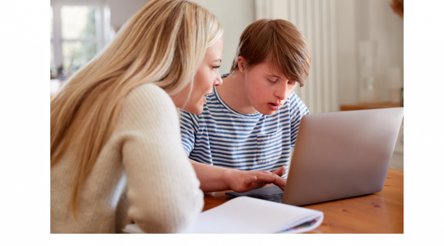 someone helping someone with a learning disability use a computer