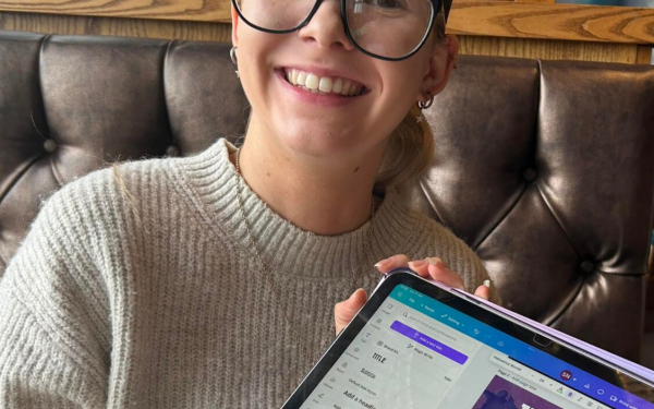 smiling woman holding up a tablet